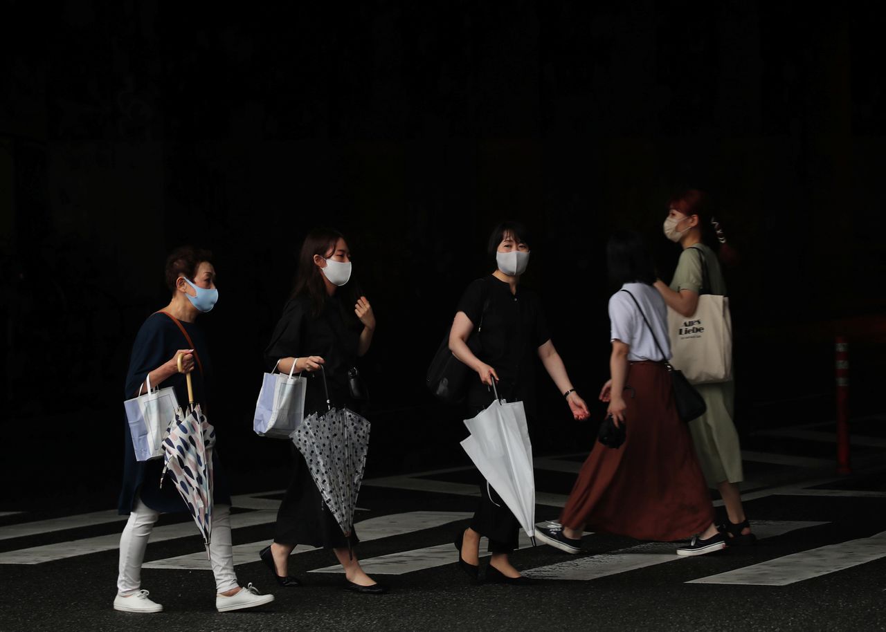 FILE PHOTO: Women wearing protective masks, amid the coronavirus disease (COVID-19) outbreak, make their way in Fukuoka, Fukuoka Prefecture, Japan, August 17, 2021. REUTERS/Kim Kyung-Hoon