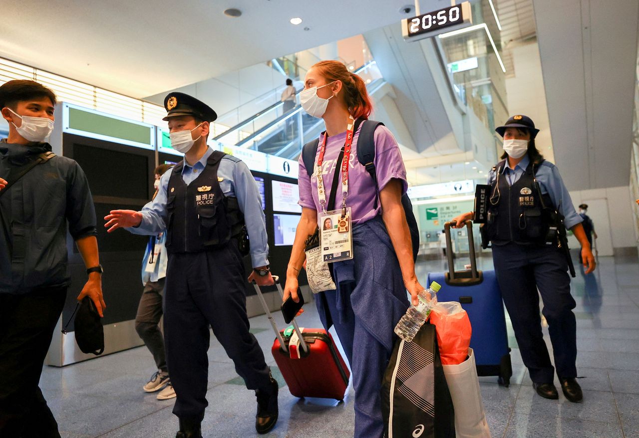 FILE PHOTO: Belarusian athlete Krystsina Tsimanouskaya is escorted by police officers at Haneda international airport in Tokyo, Japan August 1, 2021. REUTERS/Issei Kato
