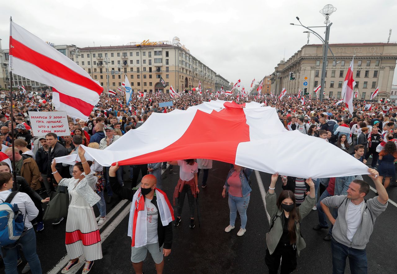 FILE PHOTO: People hold a large historical white-red-white flag of Belarus during an opposition demonstration to protest against presidential election results at the Independence Square in Minsk, Belarus August 23, 2020. REUTERS/Vasily Fedosenko