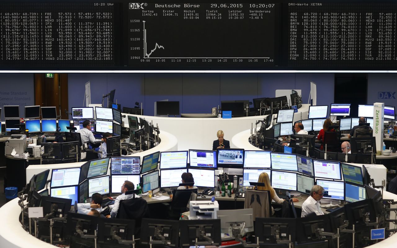 FILE PHOTO: Traders sit at their desks in front of the DAX board at the Frankfurt stock exchange, Germany, June 29, 2015. REUTERS/Ralph Orlowski