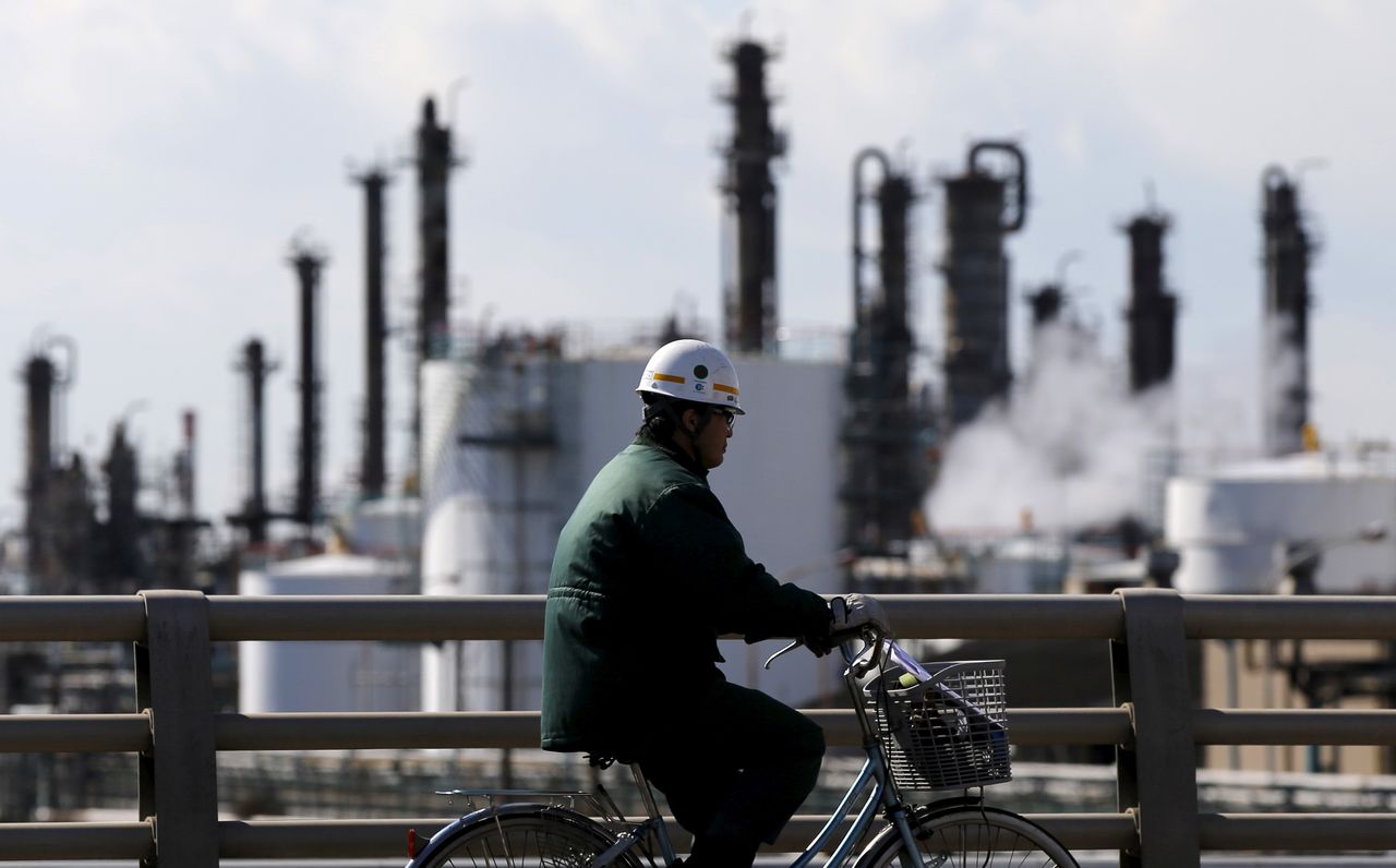 FILE PHOTO: A worker cycles near a factory at the Keihin industrial zone in Kawasaki, Japan February 17, 2016. REUTERS/Toru Hanai