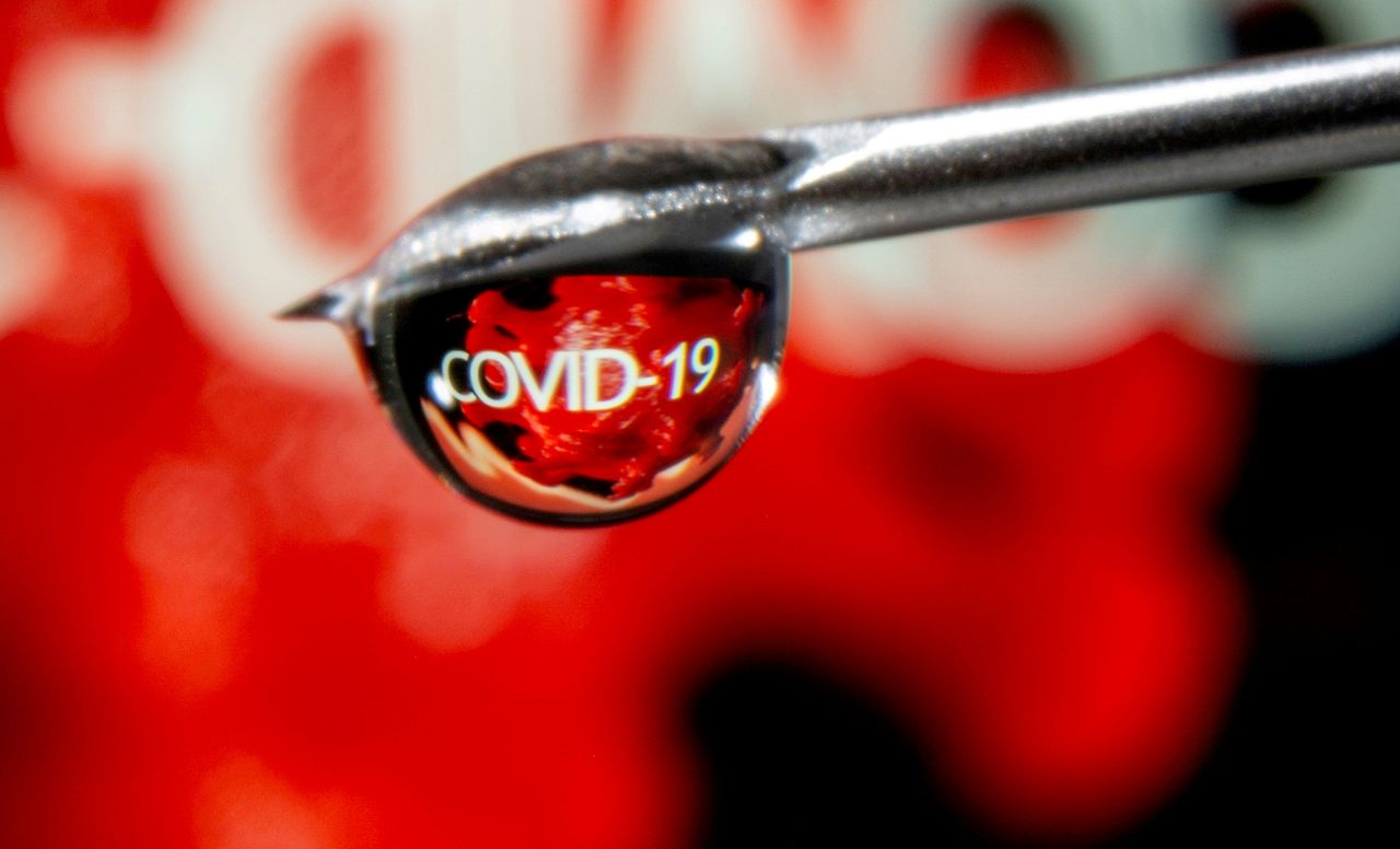 FILE PHOTO: The word "COVID-19" is reflected in a drop on a syringe needle in this illustration taken November 9, 2020. REUTERS/Dado Ruvic/Illustration