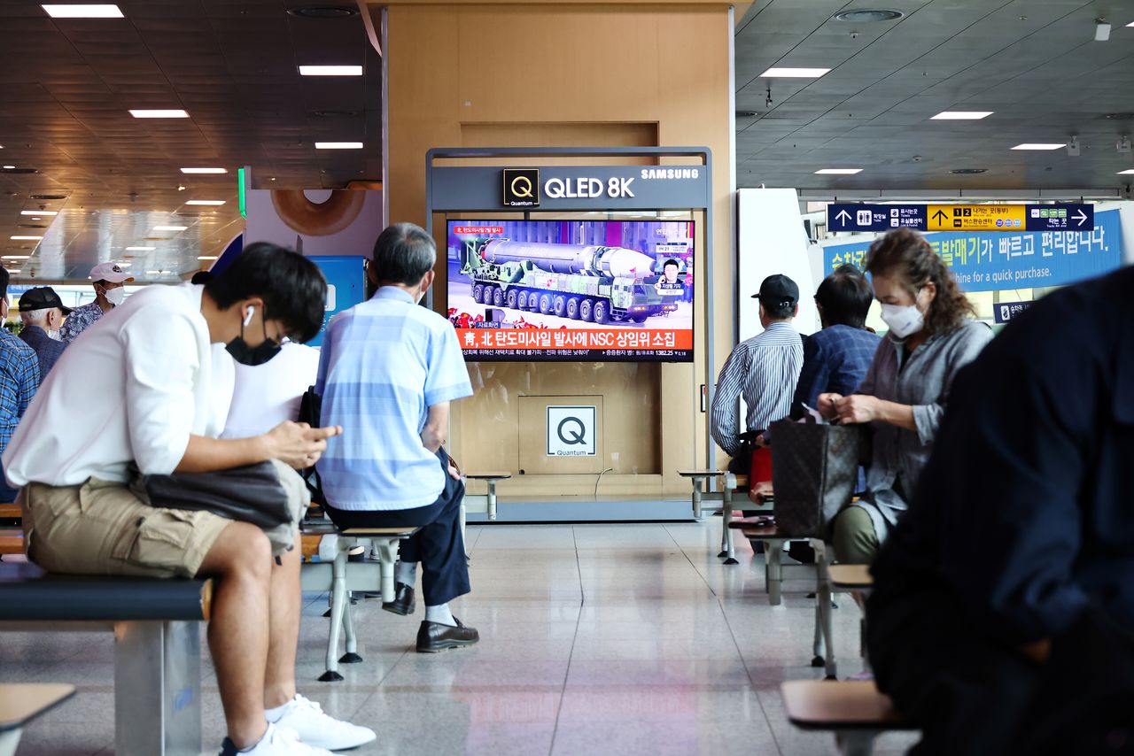 People watch a TV broadcasting file footage of a news report on North Korea firing what appeared to be a pair of ballistic missiles off its east coast, in Seoul, South Korea, September 15, 2021. REUTERS/Kim Hong-Ji