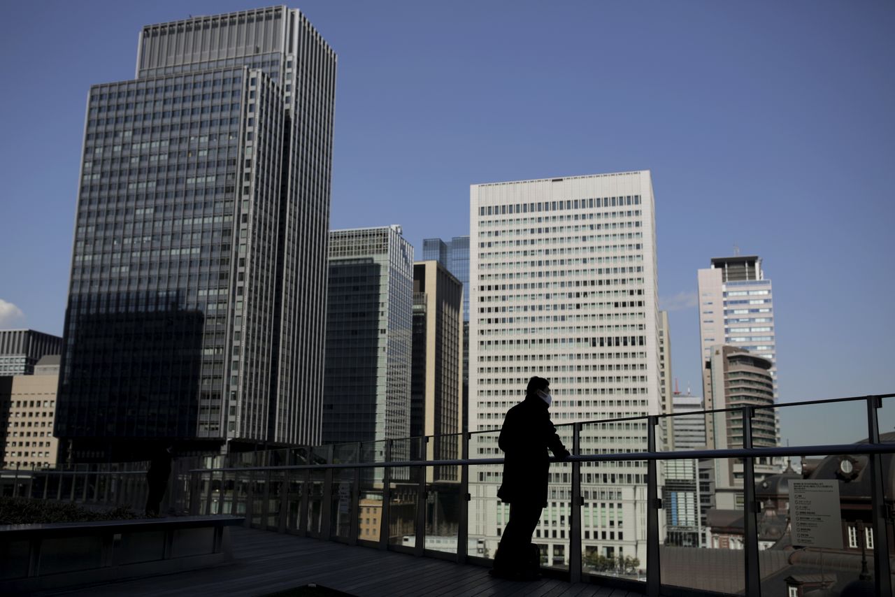FILE PHOTO: A businessman stands on a terrace overlooking a banking district in Tokyo, Japan, February 16, 2016. REUTERS/Thomas Peter
