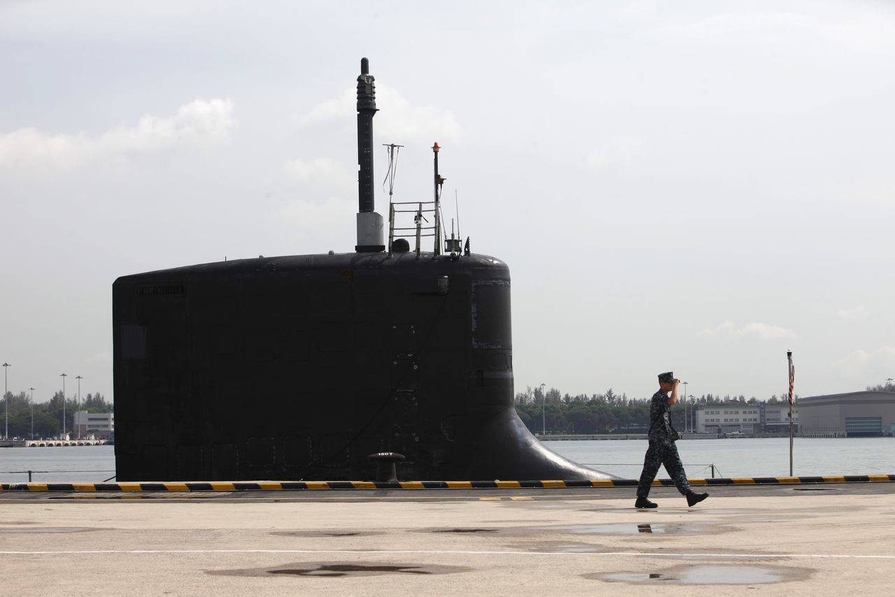 FILE PHOTO: A U.S. Navy personel walks past the USS North Carolina (SSN-777) submarine docked at Changi Naval Base in Singapore April 28, 2014. The U.S. Navy Virginia-class nuclear submarine arrived in Singapore April 26 for a routine visit as part of its second deployment to the Western Pacific. REUTERS/Edgar Su