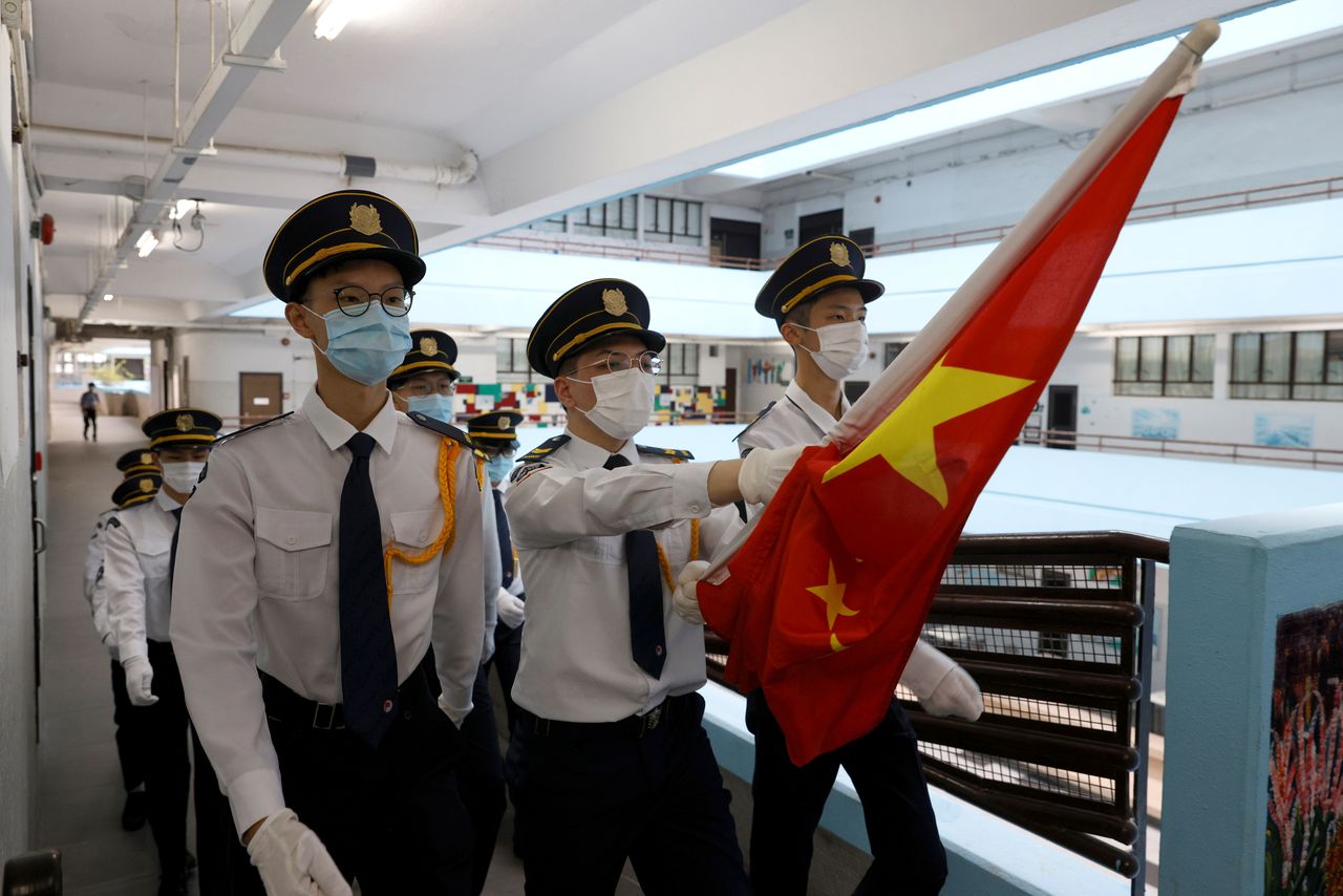 Secondary school students march with the Chinese national flag for a flag raising ceremony at the morning assembly during the first day of the new term in Hong Kong, China September 1, 2021. Picture taken September 1, 2021. REUTERS/Tyrone Siu