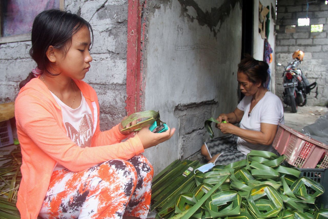 Ni Luh Nael, 13-years-old, helps her grandmother after dropping out of school during the coronavirus disease (COVID-19) pandemic in Denpasar, Bali, Indonesia, September 11, 2021. REUTERS/Wayan Sukarda