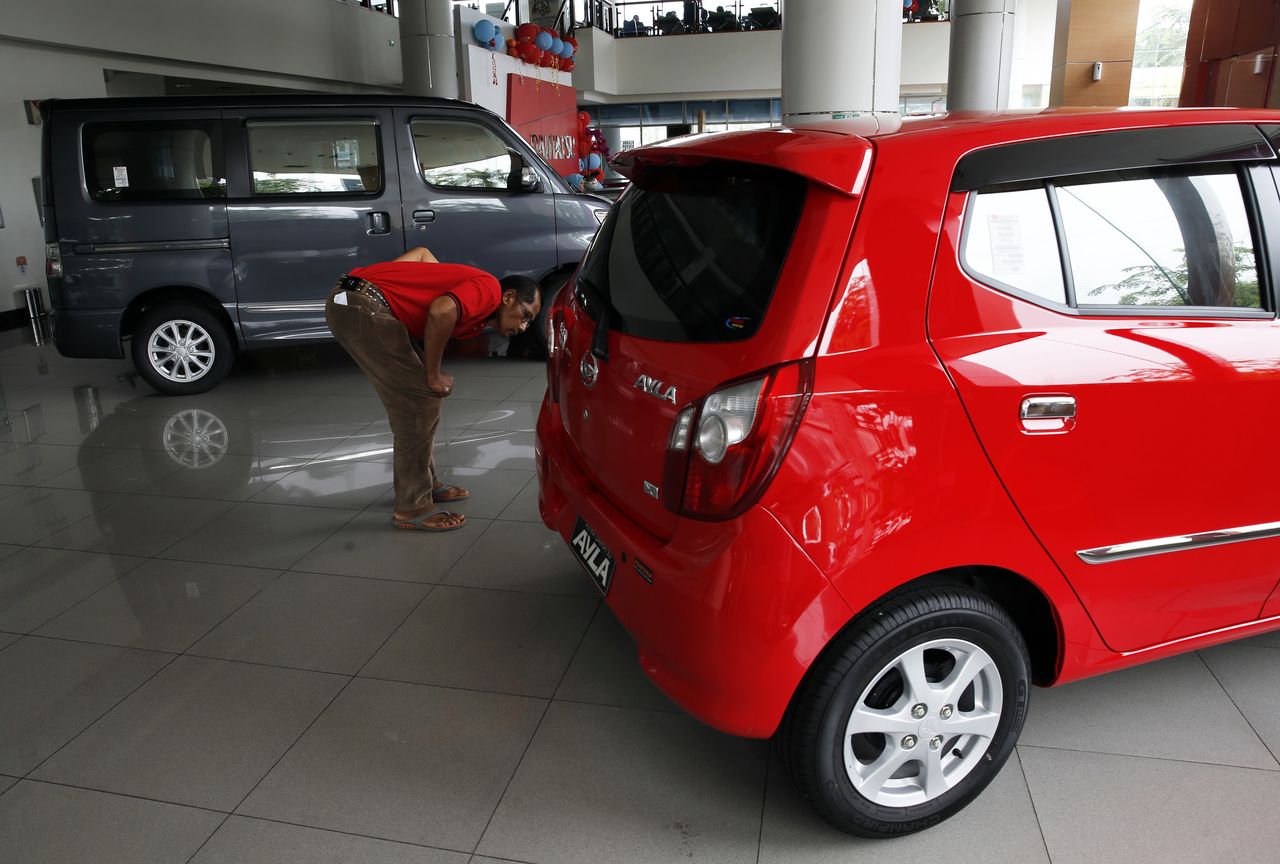 FILE PHOTO: A customer looks at a Daihatsu Ayla car at a Daihatsu showroom in Jakarta, November 11, 2014. REUTERS/Beawiharta (INDONESIA - Tags: TRANSPORT BUSINESS)