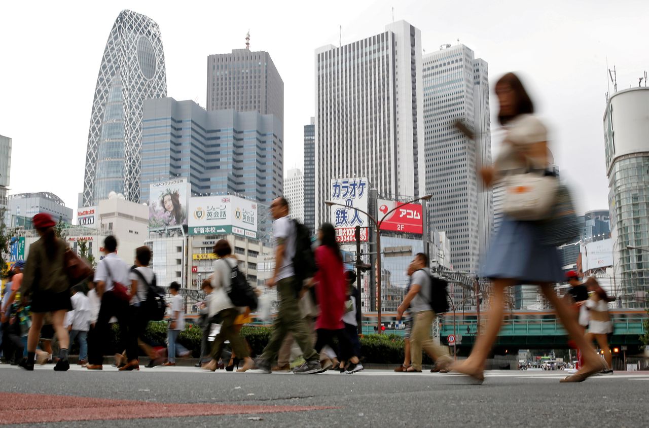 FILE PHOTO: People cross a street in front of high-rise buildings in the Shinjuku district in Tokyo, Japan, September 29, 2016. REUTERS/Toru Hanai/File Photo/File Photo