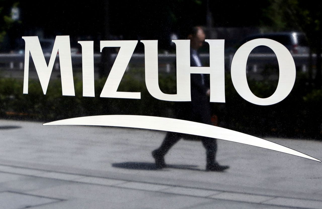 FILE PHOTO: A pedestrian is reflected in a sign showing the logo of Japan