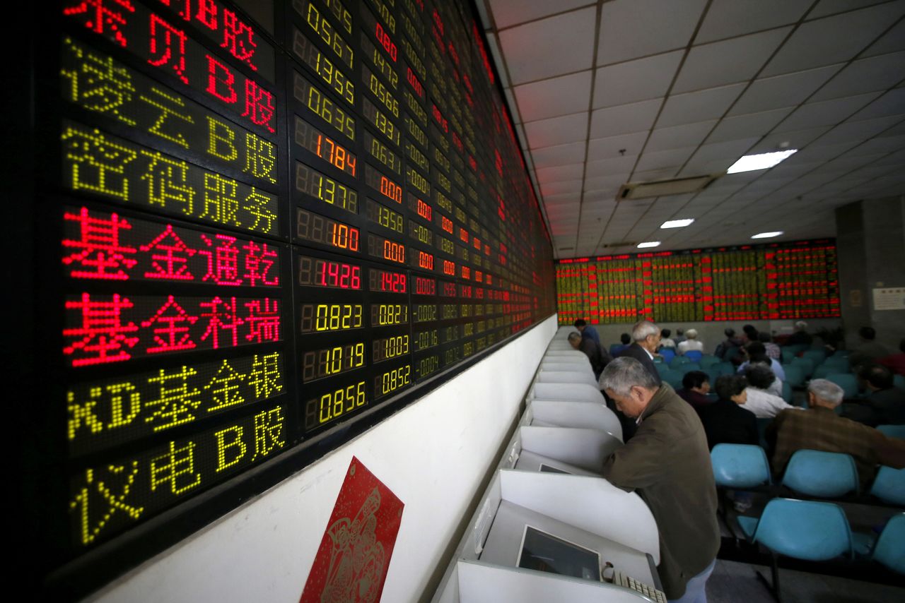 FILE PHOTO: Investors look at computer screens showing stock information at a brokerage house in Shanghai, China, April 21, 2016. REUTERS/Aly Song//File Photo