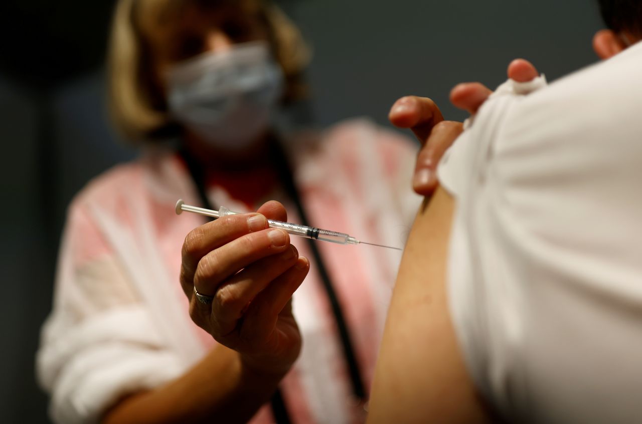 FILE PHOTO: A medical worker administers a dose of the "Comirnaty" Pfizer BioNTech COVID-19 vaccine in a vaccination center in Nantes, France, September 14, 2021. REUTERS/Stephane Mahe