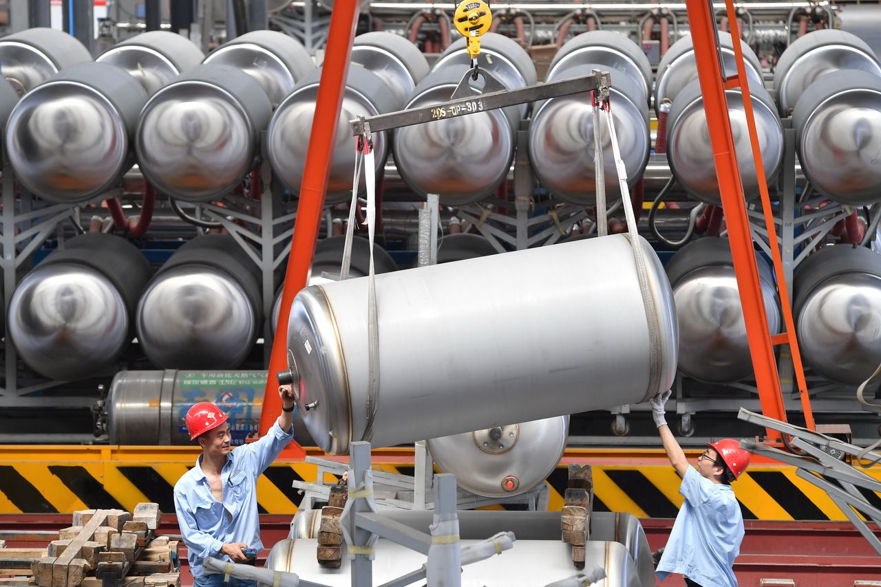 FILE PHOTO: Employees work next to tanks for liquefied natural gas (LNG) at a factory in Xian, Shaanxi province, China June 3, 2019. Picture taken June 3, 2019. REUTERS/Stringer