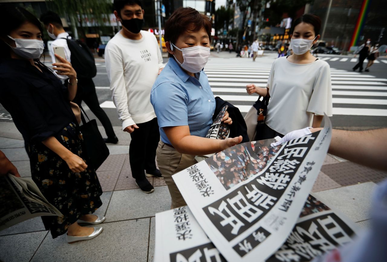 A person receives extra edition of a newspaper reporting former Japanese Foreign Minister Fumio Kishida won in a ruling party leadership election, paving the way for him to replace Prime Minister Yoshihide Suga, amid the coronavirus disease (COVID-19) pandemic, in Tokyo, Japan September 29, 2021. REUTERS/Issei Kato