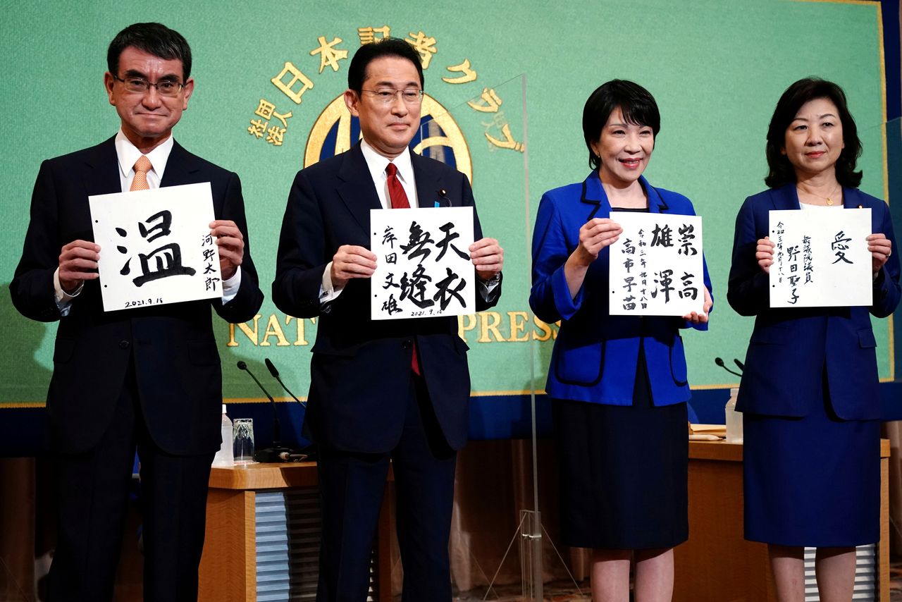 FILE PHOTO: Candidates for the presidential election of the ruling Liberal Democratic Party pose with papers with their sign and words prior to a debate session held by Japan National Press Club September 18, 2021 in Tokyo, Japan. The contenders are (L to R) Taro Kono, the cabinet minister in charge of vaccinations, Fumio Kishida, former foreign minister, Sanae Takaichi, former internal affairs minister, and Seiko Noda, former internal affairs minister. Eugene Hoshiko/Pool via REUTERS/File Photo