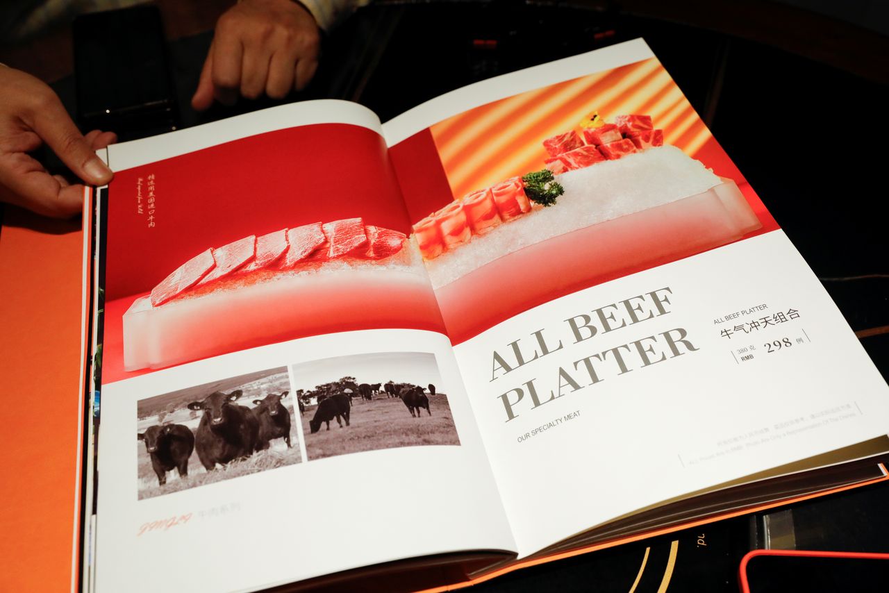 Zhong Dingming, the manager of Jingli hotpot, shows part of the U.S. beef selection on the restaurant