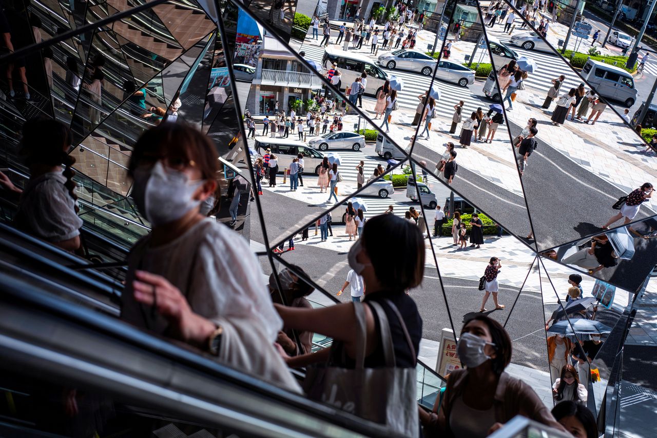 FILE PHOTO: People wearing protective masks are reflected in the mirror at a shopping mall in Tokyo amid the coronavirus disease (COVID-19) outbreak in Tokyo, Japan, August 19, 2021. REUTERS/Athit Perawongmetha/File Photo