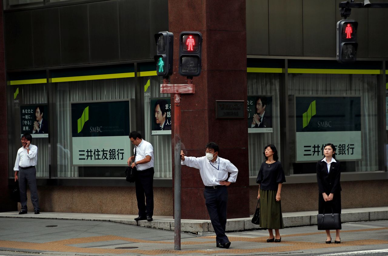 FILE PHOTO: People stand in front of a branch of Sumitomo Mitsui Banking Corp (SMBC) in Tokyo, Japan September 5, 2017. REUTERS/Kim Kyung-Hoon