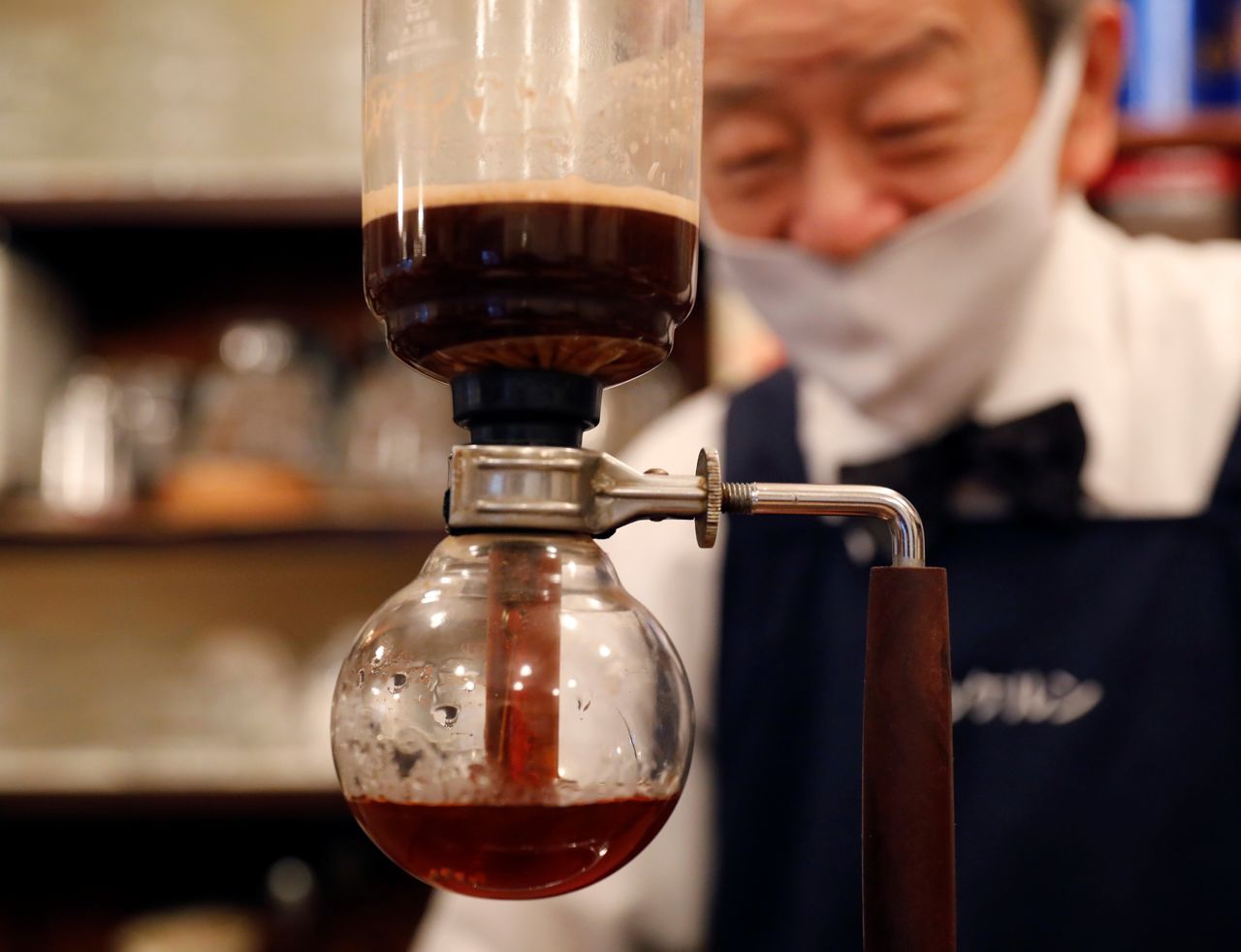 Shizuo Mori, the owner of Heckeln coffee shop brews coffee with a Syphon coffee maker at his shop in Tokyo, Japan, October 8, 2021. REUTERS/Kim Kyung-Hoon