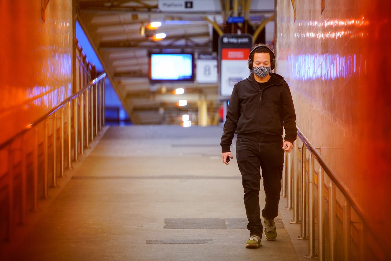 FILE PHOTO: A lone passenger wearing a protective face mask walks from a deserted train platform at Flinders Street during morning commute hours on the first day of a lockdown as the state of Victoria looks to curb the spread of a coronavirus disease (COVID-19) outbreak in Melbourne, Australia, July 16, 2021. REUTERS/Sandra Sanders
