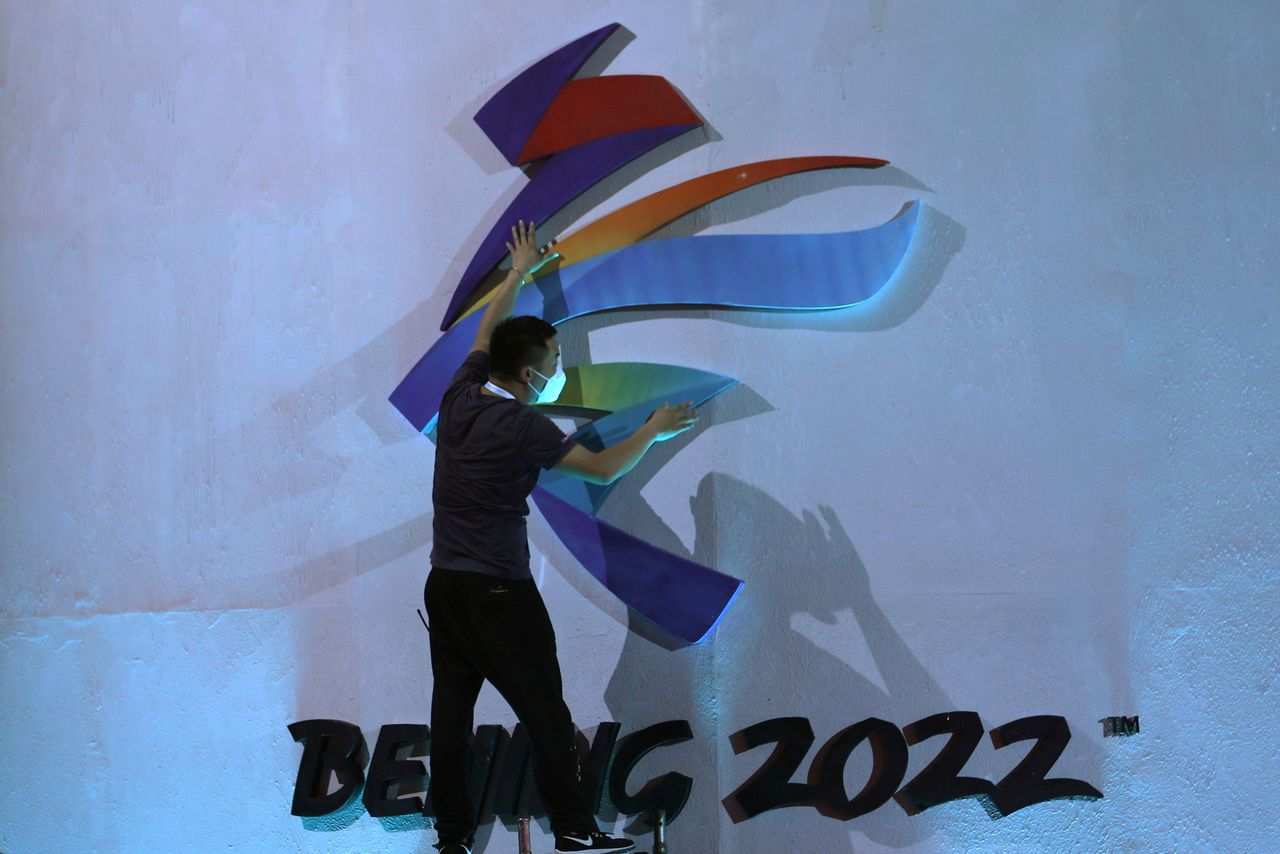 FILE PHOTO: A man adjusts an emblem of the Beijing 2022 Winter Olympic Games before a ceremony unveiling the slogan, in Beijing, China September 17, 2021. REUTERS/Tingshu Wang
