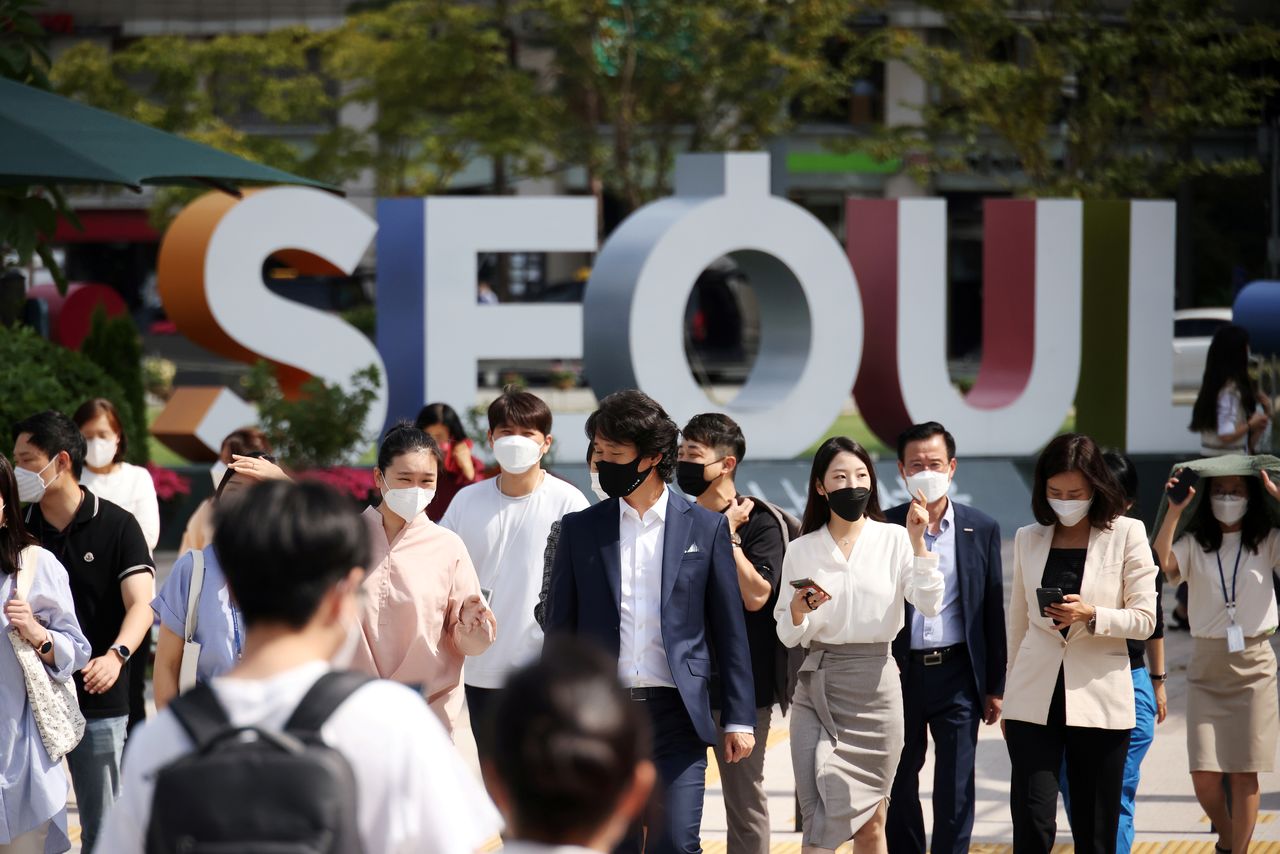FILE PHOTO: Commuters wearing masks to avoid contracting the coronavirus disease (COVID-19) walk on a zebra crossing in Seoul, South Korea, September 24, 2021.  REUTERS/Kim Hong-Ji