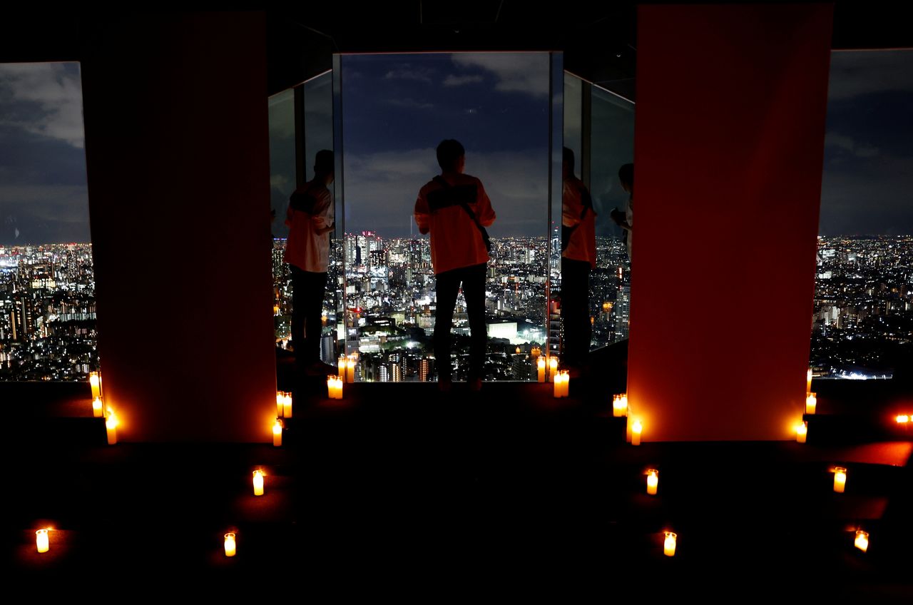 FILE PHOTO: Visitors take photos with Tokyo