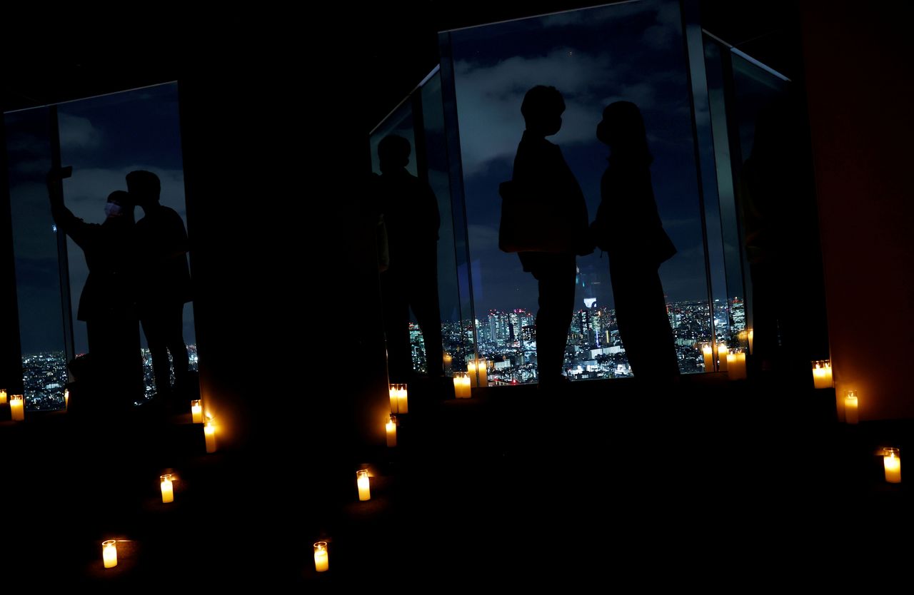 FILE PHOTO: Visitors take photos with Tokyo
