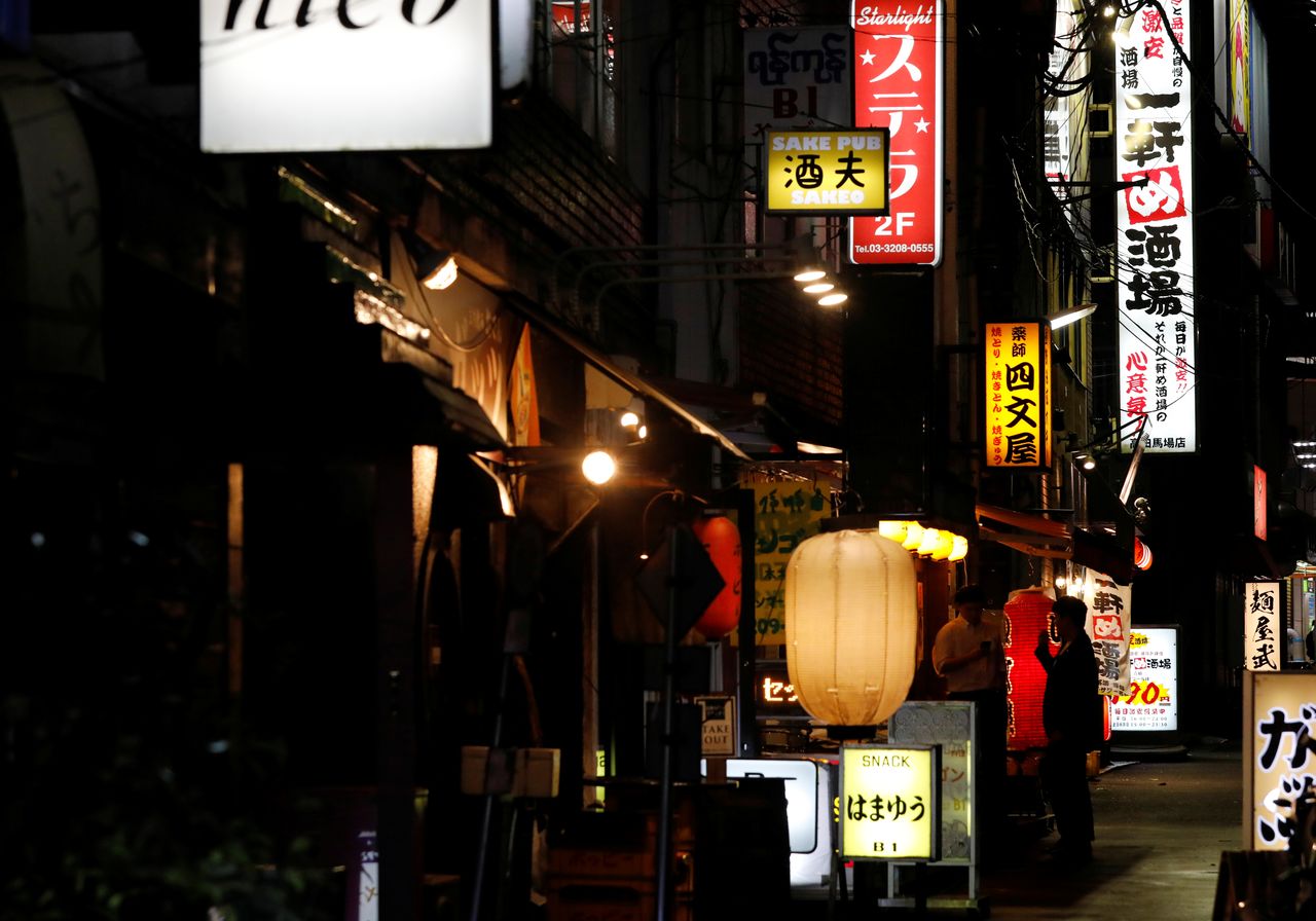 FILE PHOTO: Men talk on a street full of bars and restaurants, on the first day after Japan lifted the state of emergency imposed due to the coronavirus disease (COVID-19) outbreak, in Tokyo, Japan, October 1, 2021. REUTERS/Kim Kyung-Hoon