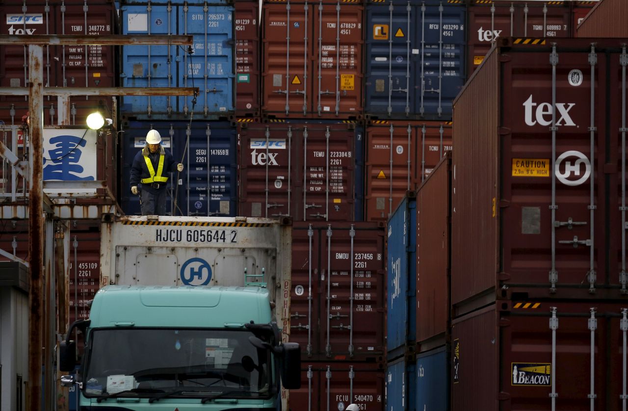 A laborer works in a container area at a port in Tokyo, Japan, March 16, 2016. REUTERS/Toru Hanai/Files