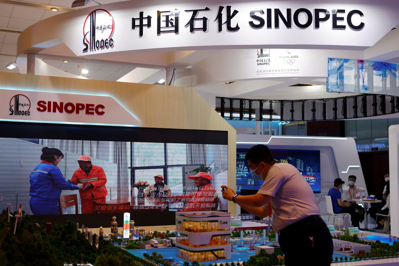 FILE PHOTO: A man takes pictures of models displayed at the Sinopec booth during the 2021 China International Fair for Trade in Services (CIFTIS) in Beijing, China September 4, 2021. REUTERS/Florence Lo