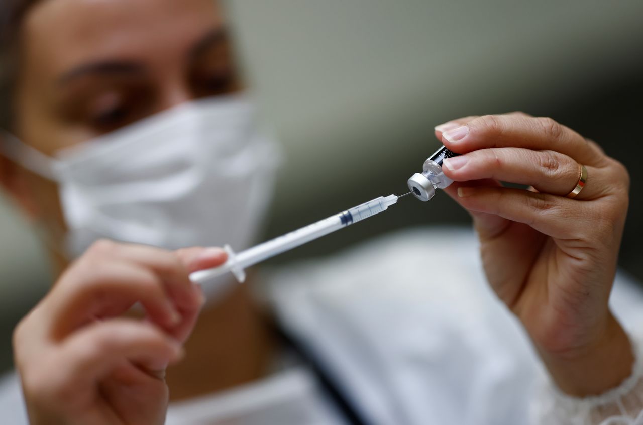 FILE PHOTO: A medical worker prepares a dose of the "Comirnaty" Pfizer BioNTech COVID-19 vaccine in a vaccination center in Nantes, France, October 6, 2021. REUTERS/Stephane Mahe