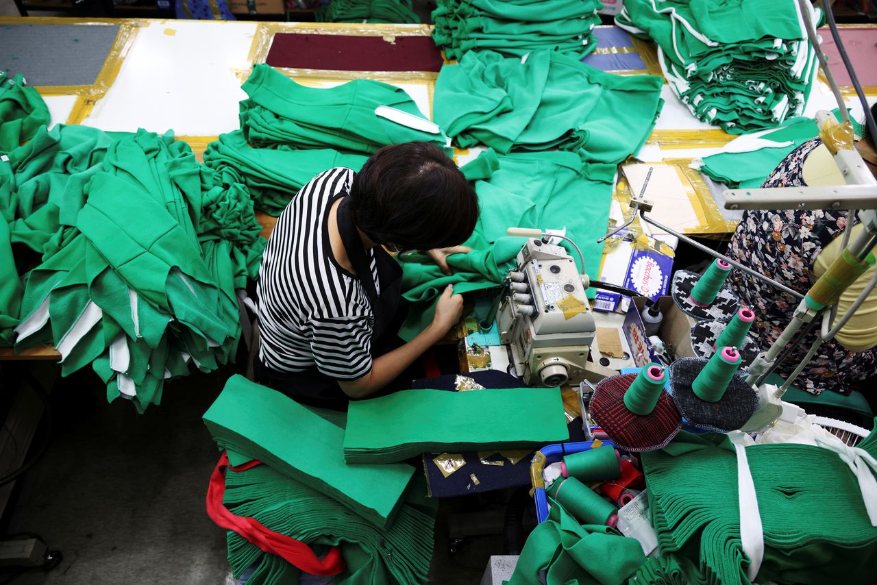 A woman works on tracksuits inspired by Netflix series "Squid Game" at a clothing factory in Seoul, South Korea, October 21, 2021. Picture taken on October 21, 2021. REUTERS/Kim Hong-Ji