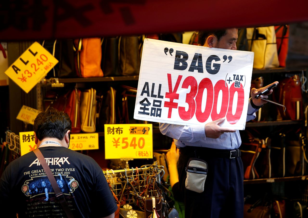 FILE PHOTO: A shop employee holds a placard to attract costomers in Tokyo, Japan May 16, 2018. REUTERS/Issei Kato/File Photo