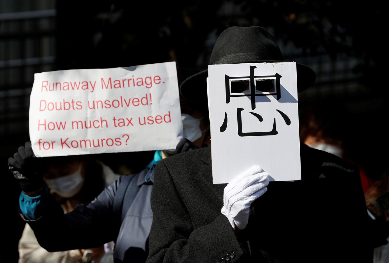 Protesters hold banners during a march against the marriage between Japan