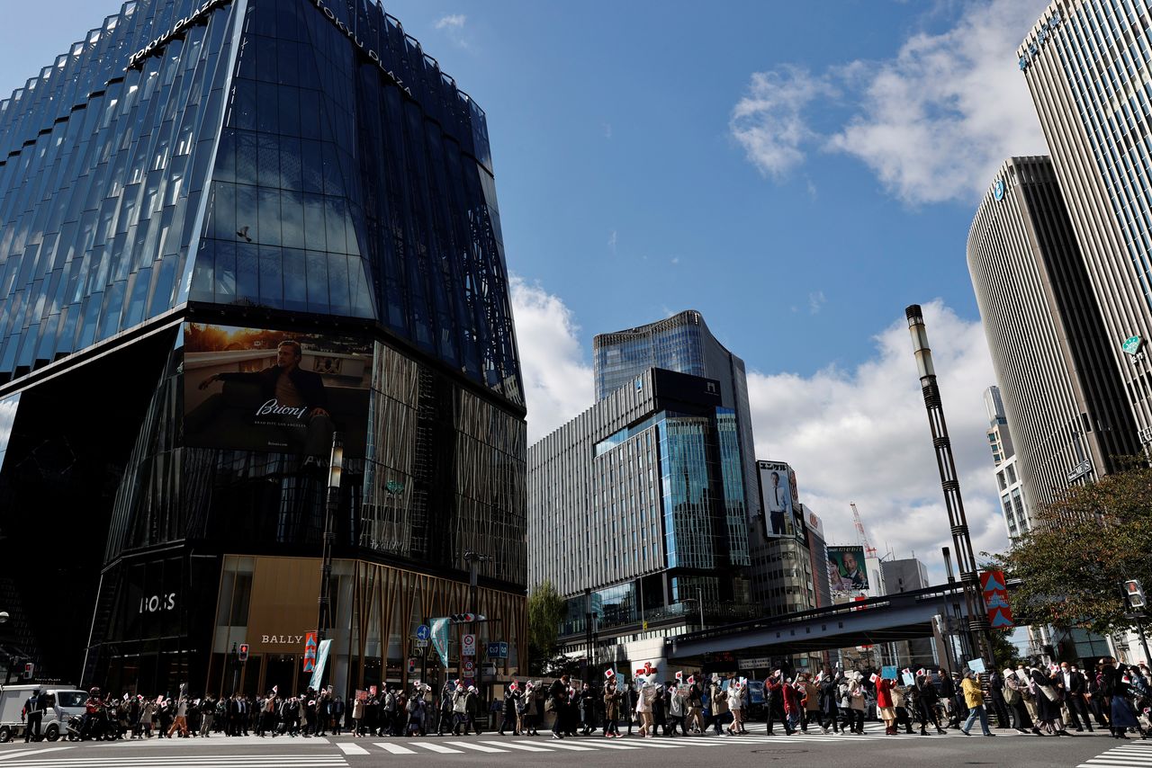 Protesters hold banners during a march against the marriage between Japan