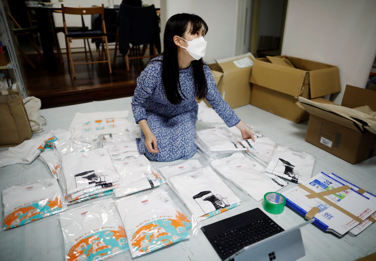 Youth activist and a member of "No Youth No Japan", Ayumi Adachi (20), conducts shipping work of T-shirts for a campaign to urge young people to vote during elections, at her house in Tokyo, Japan October 20, 2021. REUTERS/Issei Kato