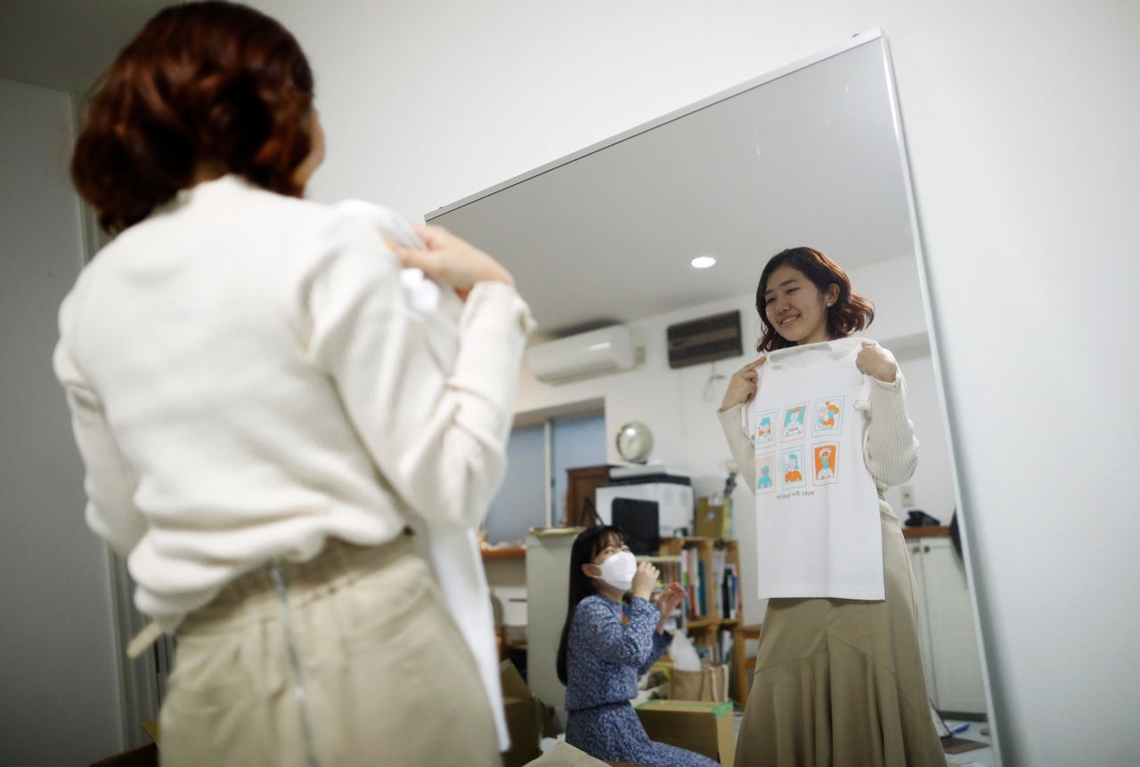 Youth activist and representative of "No Youth No Japan", Momoko Nojo, chats with a group member Ayumi Adachi (20), as they carry out shipping work of T-shirts for a campign to urge young people to vote during elections, in Tokyo, Japan October 20, 2021. REUTERS/Issei Kato