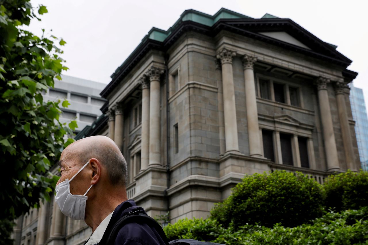FILE PHOTO: A man stands in front of the headquarters of Bank of Japan in Tokyo, Japan, May 22, 2020. REUTERS/Kim Kyung-Hoon