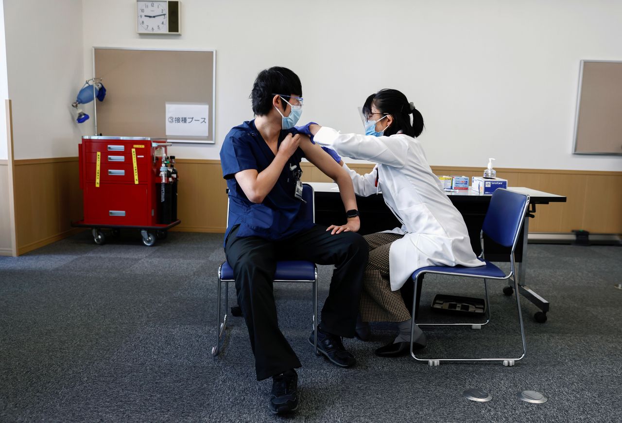A medical worker receives a dose of the coronavirus disease (COVID-19) vaccine as Japan launches its inoculation campaign, at Tokyo Medical Center in Tokyo, Japan February 17, 2021. Behrouz Mehri/Pool via REUTERS