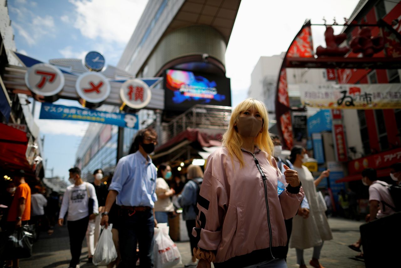 FILE PHOTO: Shoppers walk at the Ameyoko shopping district, also called Ameya-Yokocho, where Tokyo’s biggest street food market is located, in Tokyo, Japan June 5, 2021. REUTERS/Issei Kato