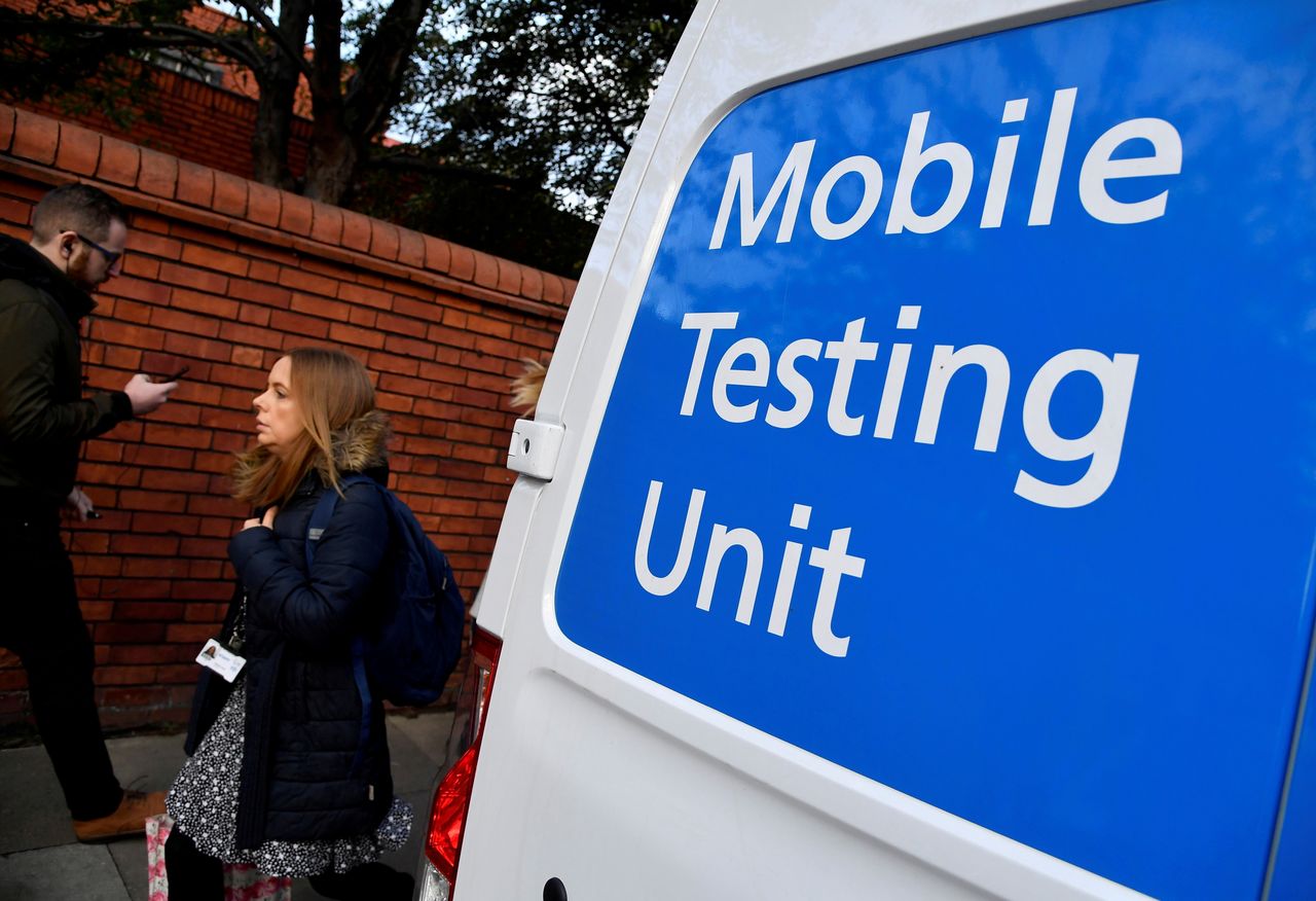 FILE PHOTO: People walk past a COVID-19 Mobile Testing Unit van, amidst the spread of the coronavirus disease (COVID-19), in London, Britain, October 21, 2021. REUTERS/Toby Melville