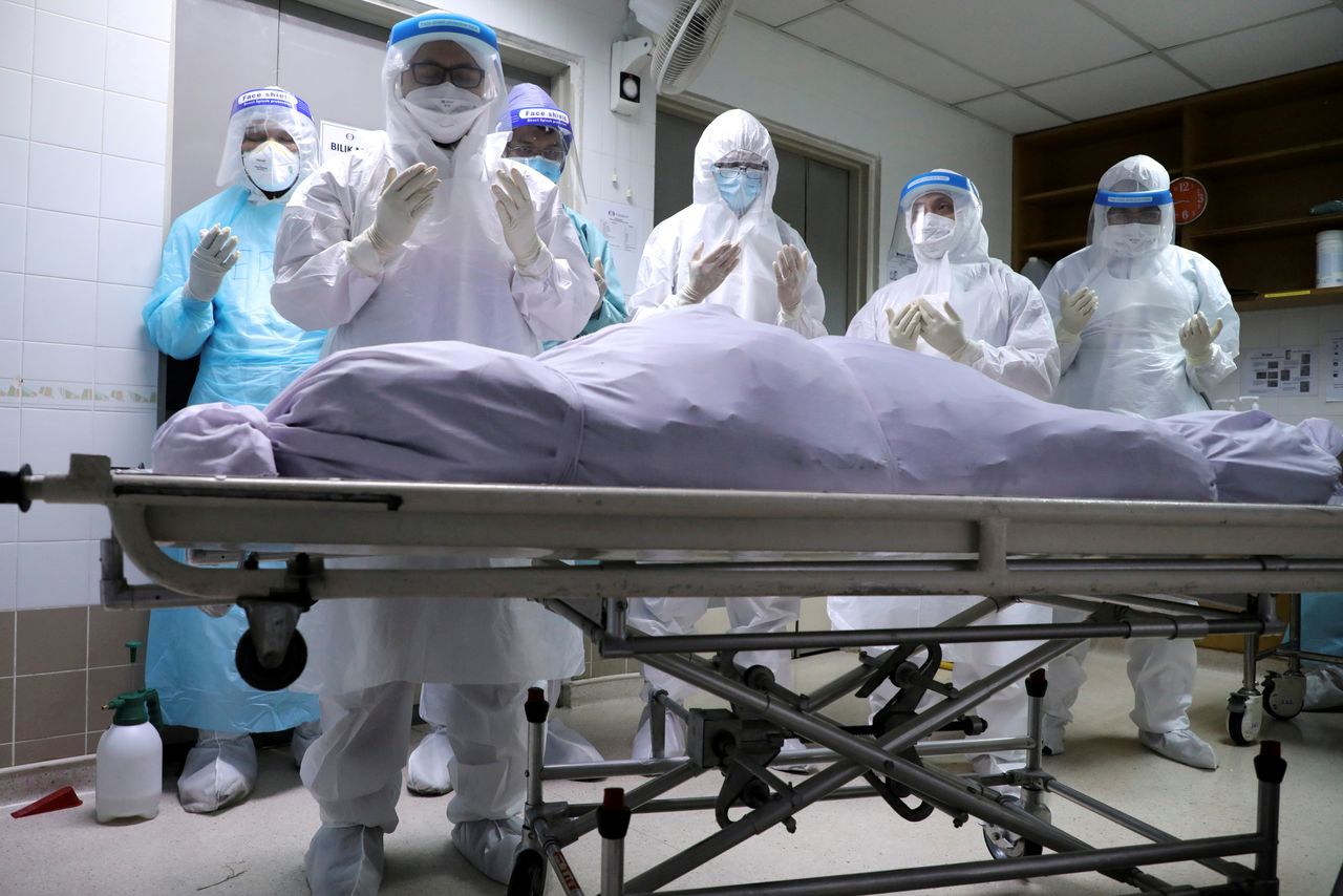 FILE PHOTO: Family members of a victim of the coronavirus disease (COVID-19) pray at a hospital mortuary before burial, in Kuala Lumpur, Malaysia May 23, 2021. REUTERS/Lim Huey Teng/File Photo