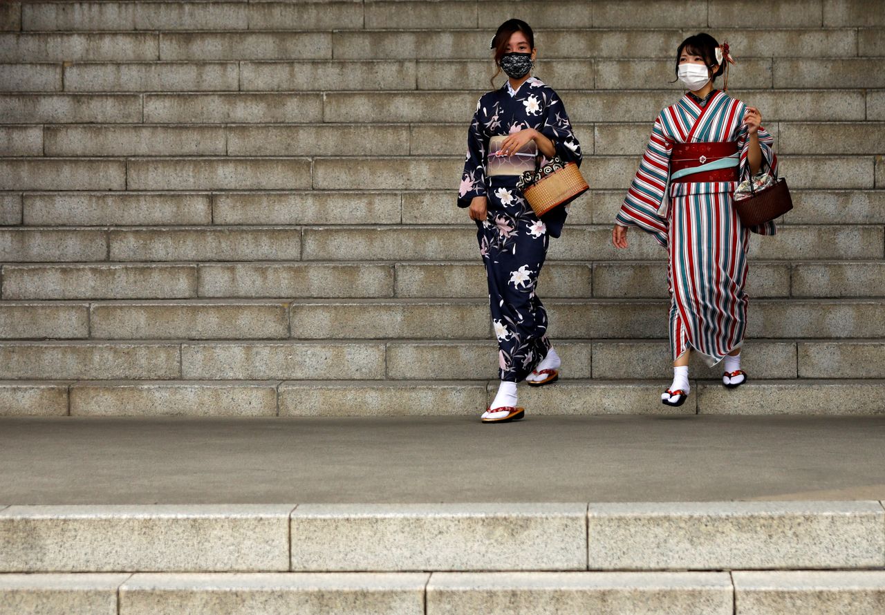Kimono-clad tourists wearing protective face masks are seen at a temple at Asakusa district, a popular sightseeing spot, amid the coronavirus disease (COVID-19) outbreak in Tokyo, Japan October 13, 2020.   REUTERS/Issei Kato/Files
