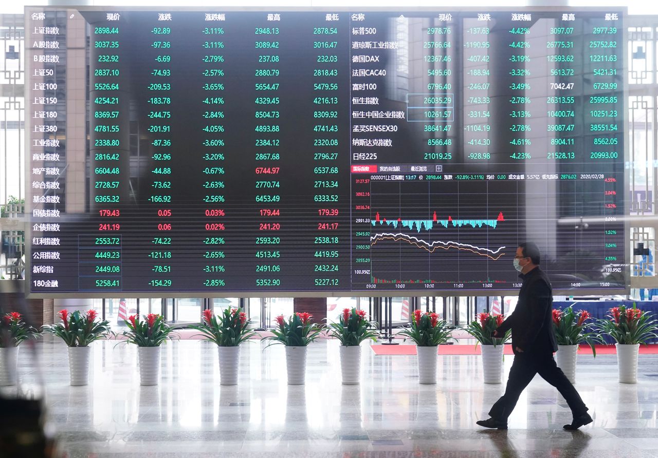 FILE PHOTO: A man wearing a face mask is seen inside the Shanghai Stock Exchange building, as the country is hit by a novel coronavirus outbreak, at the Pudong financial district in Shanghai, China February 28, 2020.  REUTERS/Aly Song