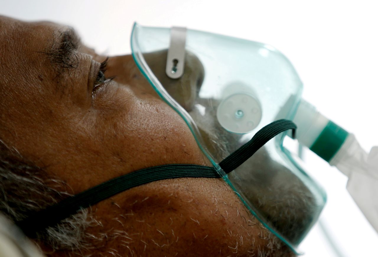 FILE PHOTO: A patient suffering from the coronavirus disease (COVID-19) breathes with a non-rebreather mask in an isolation room at a hospital in Bogor, Indonesia January 26, 2021. REUTERS/Willy Kurniawan/File Photo