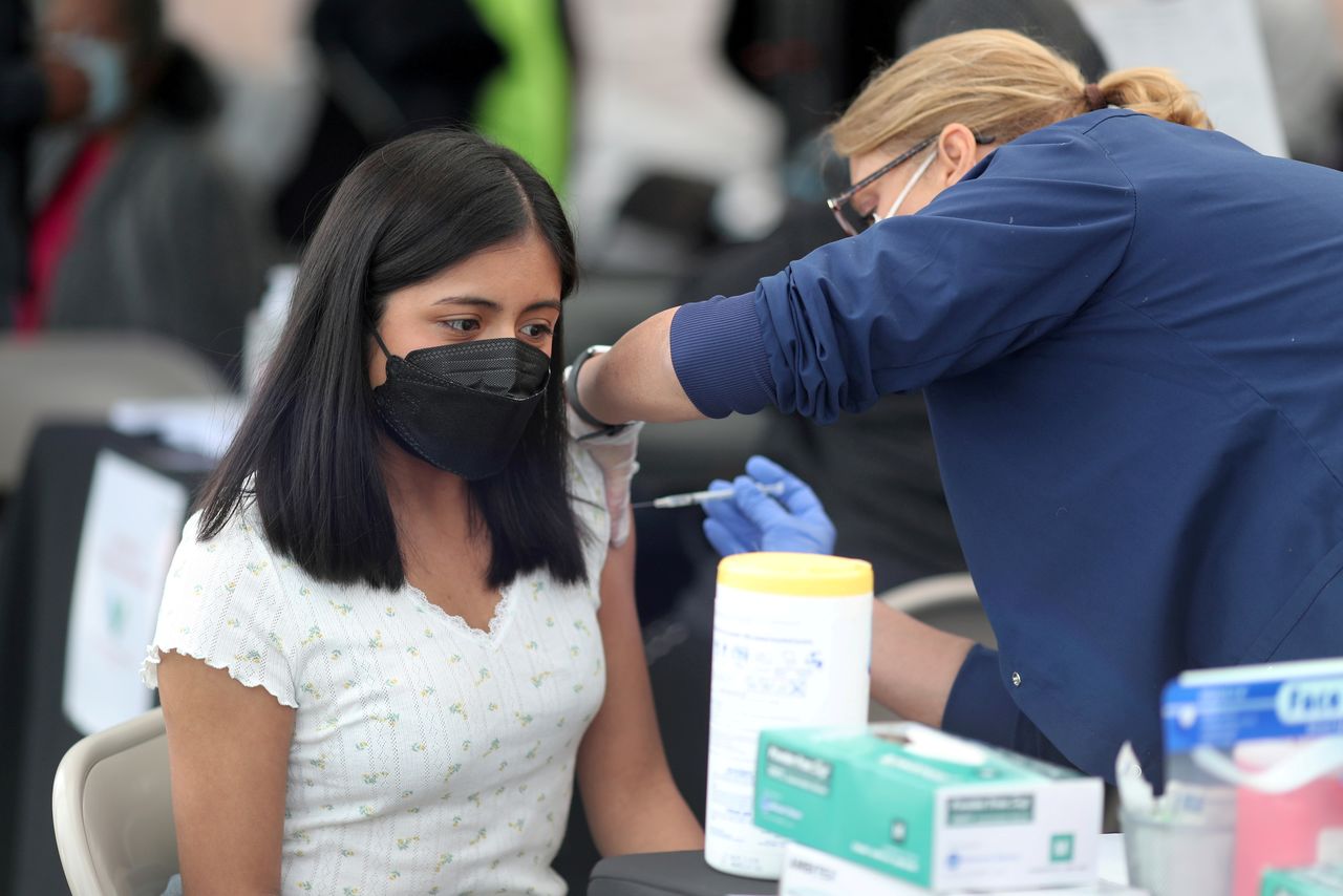 FILE PHOTO: A woman receives a coronavirus disease (COVID-19) vaccination, at Jordan Downs in Los Angeles, California, U.S., March 10, 2021. REUTERS/Lucy Nicholson/File Photo