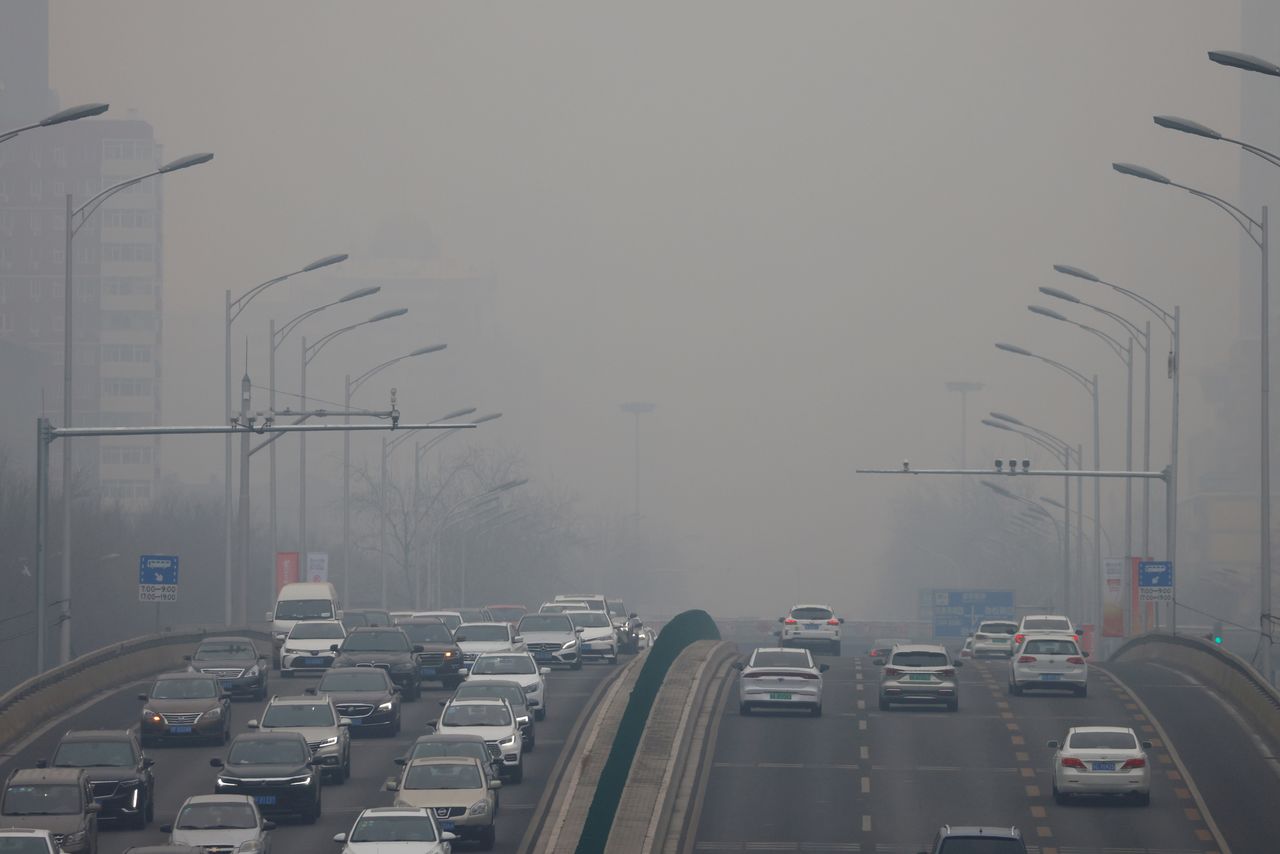 FILE PHOTO: Cars move on a road during a day with polluted air, following the outbreak of the coronavirus disease (COVID-19), in Beijing, China February 13, 2021. REUTERS/Carlos Garcia Rawlins//File Photo