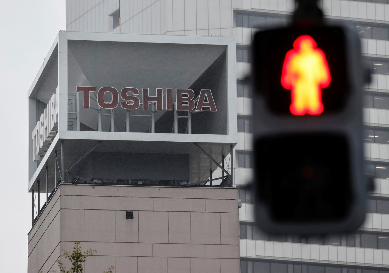 FILE PHOTO: The logo of Toshiba Corp. is seen next to a traffic signal atop of a building in Tokyo, Japan November 9, 2021. REUTERS/Issei Kato