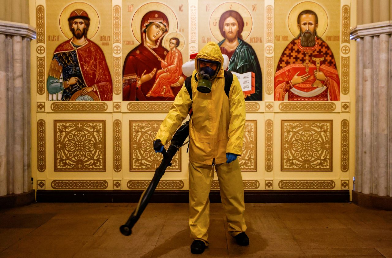 FILE PHOTO: A specialist wearing personal protective equipment (PPE) sprays disinfectant while sanitizing a chapel inside the building of the Leningradsky railway station amid the outbreak of the coronavirus disease (COVID-19) in Moscow, Russia October 19, 2021. REUTERS/Maxim Shemetov/File Photo